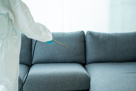 Sanitary staff sanitizing a surface inside the building cause coronavirus or COVID-19 disease pandemic. Cleaning worker using a cleaning chemical spray on the surface to sanitize from COVID19 virus.の写真素材