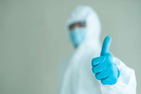 Unrecognizable specialist doctor dress up a medical PPE suit before working in hospital.の写真素材