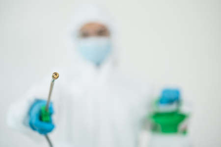 Sanitary staff sanitizing a surface inside the building cause virus disease pandemic. Cleaning worker using a cleaning chemical spray on the surface to sanitize from virus.の写真素材