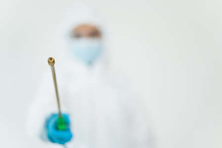 Sanitary staff sanitizing a surface inside the building cause virus disease pandemic. Cleaning worker using a cleaning chemical spray on the surface to sanitize from virus.の写真素材