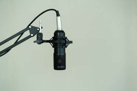 Professional condenser microphone on a microphone holder close up with copyspace. Live podcast and streaming concept at home.の写真素材