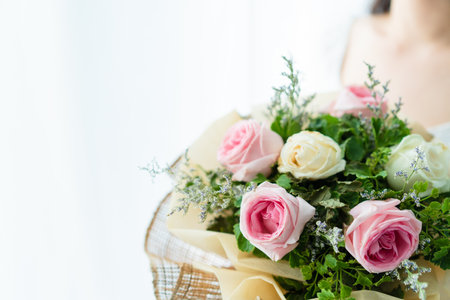 Happy Asian beautiful young woman holding a bouquet of flowers in wedding ceremony. Woman smiling and holding a beautiful flower bouquet in Valentine day or wedding party.の写真素材