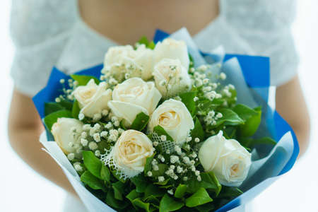 Happy Asian beautiful young woman holding a bouquet of flowers in wedding ceremony. Woman smiling and holding a beautiful flower bouquet in Valentine day or wedding party.の写真素材