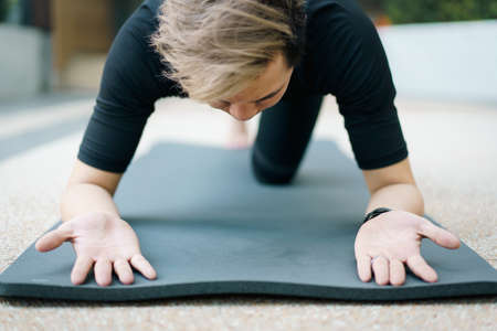 Active Asian young man making an outdoor body weight exercise close up, sportsman doing body weight workout by pushup and plank. Asian sportsman exercising for muscle and body building.の写真素材
