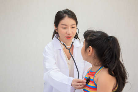 Professional specialist doctor examining about breathing in Asian little girl in kids hospital. Doctor kindly checking and listening heartbeat in little girl.の写真素材