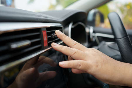 Unrecognizable man adjusting the vehicle air conditioner grille for better air flow, modern vehicle...
