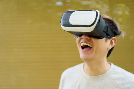 Active Asian sportsman doing a weight training exercise by using dumbbell and virtual reality - VR...