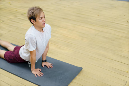 Active sportsman doing a plank - yoga exercise and making a video call with a friend and online sport training coach online. Healthy sport man making a body building workout with online instructor.の写真素材