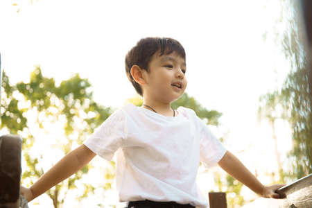 Happy Asian little boy enjoy playing and walking at the park. Little boy portrait at the park and playground.の写真素材
