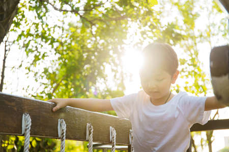 Happy Asian little boy enjoy playing and walking at the park with daddy close up, Asian boy have a beautiful smiling while looking at his father. Little boy portrait at the park and playground.の写真素材