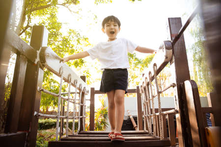 Happy Asian little boy enjoy playing and walking at the park. Little boy portrait at the park and playground.の写真素材