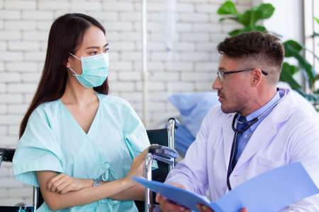 Asian woman got a sickness from flu virus having a consultation with professional doctor in hospital. Doctor explaining about healthcare and sickness avoidance. Medical consultant service.の写真素材