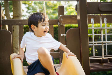 Happy Asian little boy enjoy playing and walking at the park with daddy close up, Asian boy have a...