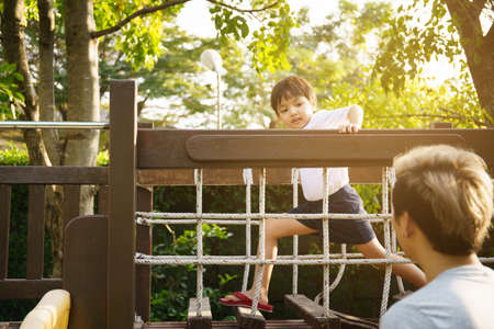 Happy Asian little boy enjoy playing and walking at the park with daddy close up, Asian boy have a beautiful smiling while looking at his father. Little boy portrait at the park and playground.の写真素材