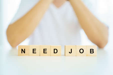 Unemployment people showing the word "need job" on the wooden blocks.の写真素材
