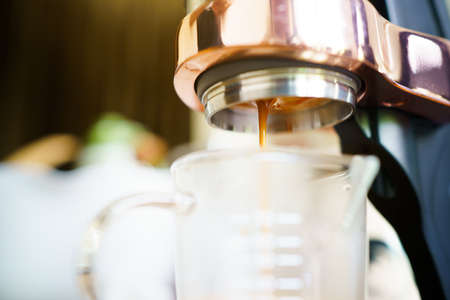 Barista brewing the espresso coffee by using high pressured espresso machine in a small coffee shop. Coffee machinery in coffee shop.の写真素材