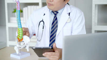 Professional specialized doctor talking with patient via medical online video conference on laptop computer, tele medical service concept. orthopedic doctor giving a medical consulting.の写真素材