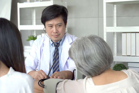 Elder woman talking and having a consulting to doctor about disease. Wellness and health care concept.の写真素材