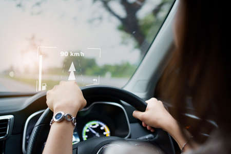 Woman driver driving the modern EV car - electric vehicle on the road and activate auto driving assist and navigation. Land vehicle technology  concept.の写真素材