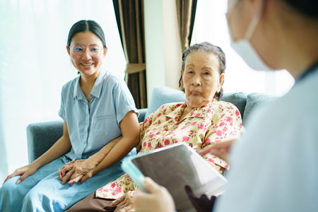 Asian young woman taking her mother to see an orthopedic doctor at hospital. Elder woman talking and having a consulting with doctor about disease. Wellness and health care concept.の写真素材