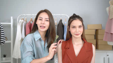 Professional make up artist using a dry powder cosmetic applying on young beautiful woman client close up. Makeup artist using professional makeup brush apply on woman face.の写真素材