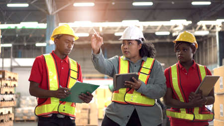 Team of professional engineers or foreman working and discussing together in the factory, Engineer walking around the warehouse to inspect a machines.の写真素材