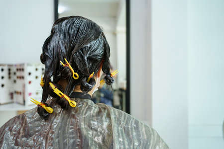 Professional hair stylist making a hair coloring and treatment in beauty and salon shop. Woman changing a hair color in professional salon shop.の写真素材