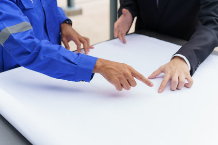 Professional Asian foreman and construction manager talking - discussing about building structure plant together. Businessman and construction engineer having a discussion.の写真素材