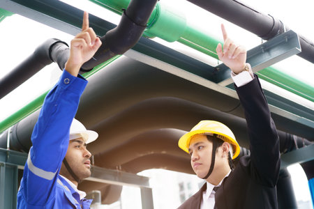 Professional Asian foreman and construction manager talking - discussing about building structure plant together. Businessman and construction engineer having a discussion.の写真素材