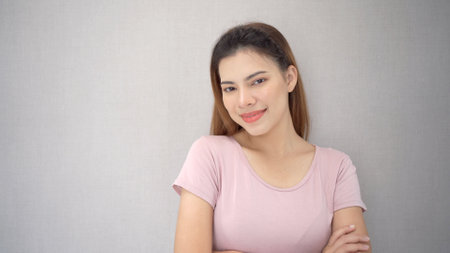Happy Asian young woman smiling and looking at the camera portrait with copy space. Confident young woman crossed arms and looking at camera portrait.の写真素材