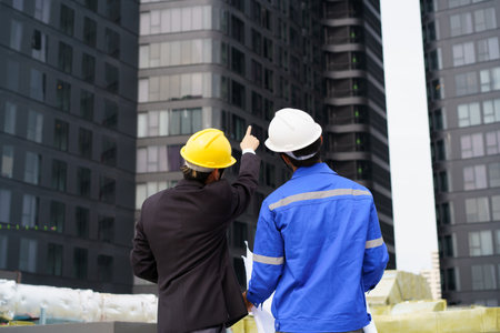 Professional Asian foreman and construction manager talking - discussing about building structure plant together. Businessman and construction engineer having a discussion.の写真素材