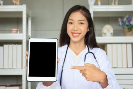 Empty blank screen tablet isolated with clipping path. Healthcare and wellness concept. Female doctor showing and pointing on tablet screen.の写真素材