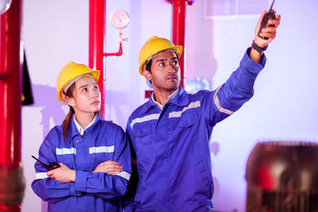 Professional building system maintenance engineers inspecting or checking the pumping and gas system in the maintenance service area in building.の写真素材