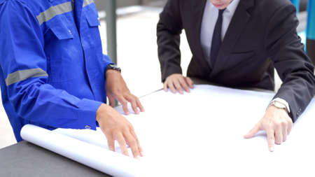 Professional Asian foreman and construction manager talking - discussing about building structure plant together. Businessman and construction engineer having a discussion.の写真素材