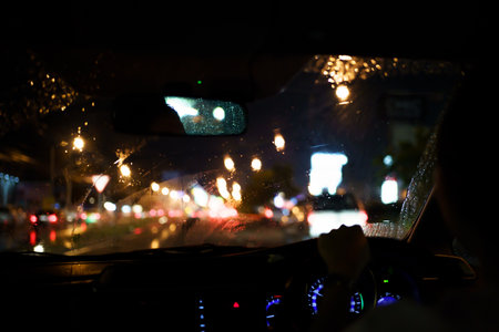 Asian woman driving a car in the rain storm at night on highway.の写真素材