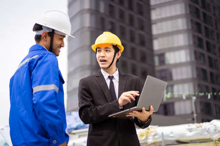 Professional Asian foreman and construction manager talking - discussing about building structure plant together. Businessman and construction engineer having a discussion.の写真素材