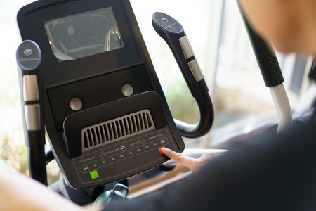 Active Asian young man making a cardio exercise on the elliptical exercise machine in the gym. Fat burn and body muscle building. bodybuilding workout concept.の写真素材