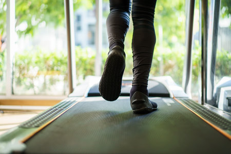 Active Asian sportsman making a cardio exercise by running on the treadmill machine in a fitness or gym, healthy sport man doing a cardio workout.の写真素材