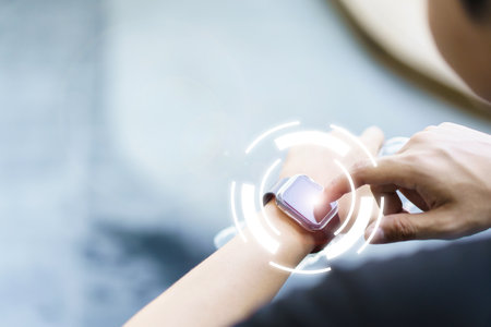 Active Asian young sportsman using a smartwatch or smart fitness band to track his outdoor workout and activities, man reviewing an exercise and health information after finished outdoor workout.の写真素材