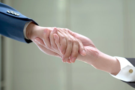 unrecognizable businesspeople doing a handshake together after done and completed business negotiation. Trust in business partnership and colleague. Successful in business conceptの写真素材