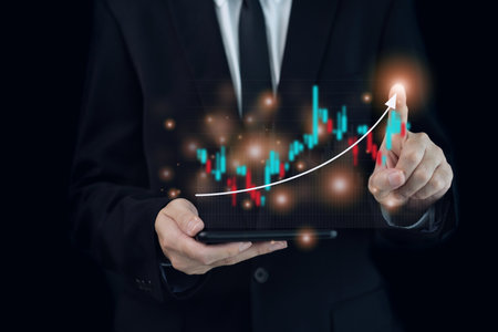 Unrecognizable businessman holding a digital tablet and showing a business chart or bar graph with a year 2023 in hologram with copy space. A successful and growth in business in 2023 concept.の写真素材