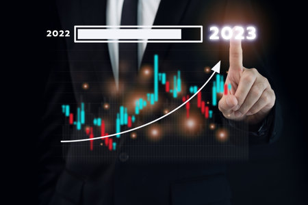Unrecognizable businessman holding a digital tablet and showing a business chart or bar graph with a year 2023 in hologram with copy space. A successful and growth in business in 2023 concept.の写真素材