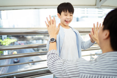 An Asian little boy touching a hands with his father.の写真素材