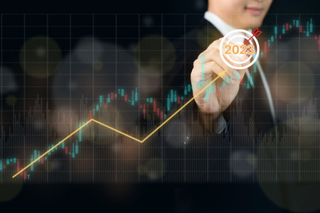 Unrecognizable businessman holding a digital tablet and showing a business chart or bar graph with a year 2023 in hologram with copy space. A successful and growth in business in 2023 concept.の写真素材