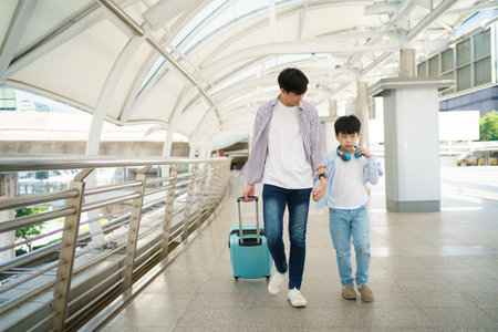 Father taking his son going to school, a man holding child hand while walking to school together.の写真素材