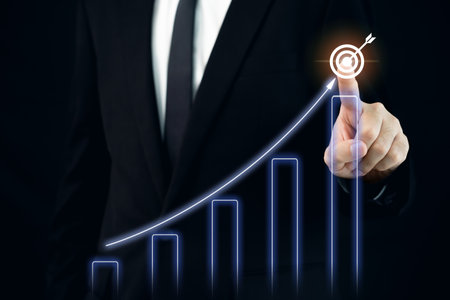 Concept of business and financial growth. Unrecognizable businessman in business smart casual pointing his finger on the graphic chart in business report.の写真素材