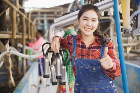 Professional Asian female animal husbandry working in dairy milk farm. Portrait of Asian female livestock farm worker standing in the dairy or milk cow farmhouse.の写真素材