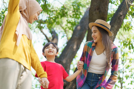 Happy Asian little boy and a women walking in the park, Asian muslim woman and little boy relaxing in the park.の写真素材