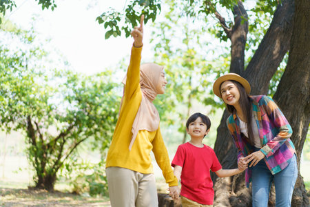 Happy Asian little boy and a women walking in the park, Asian muslim woman and little boy relaxing in the park.の写真素材