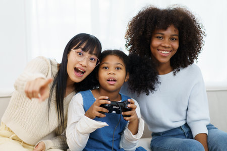 Concept of diversity in ethnic people spending a time together in a weekend. A diverse group and generation people relaxing and playing a video game together in living room.の写真素材